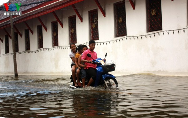 Gia đình anh Ệc, di chuyển trong nước lụt tại đường Maharaj